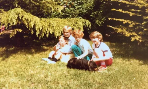 amily picture of young Loic Moutault together with his brothers, cousins and the family dog